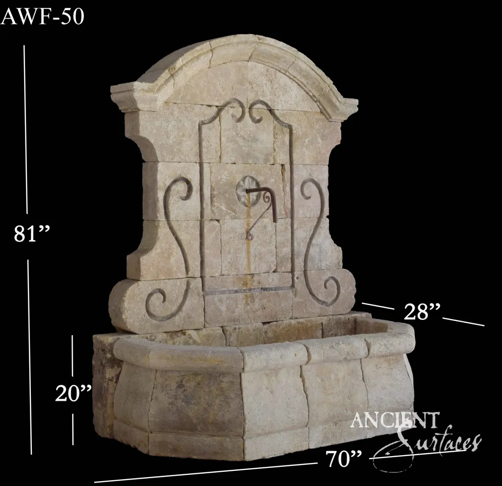 Reclaimed limestone wall fountain with wrought-iron scrollwork on an arched backplate over a rectangular basin